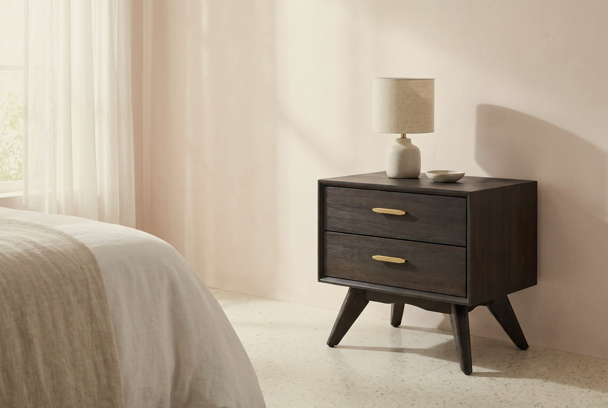 Siniscola dark acacia nightstand with a ceramic lamp beside a bed in a Palm Beach bedroom with a pale blush plaster wall and a terrazzo floor