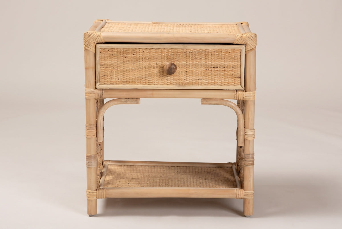 The Sinnai nightstand in natural rattan, front view on a light studio backdrop
