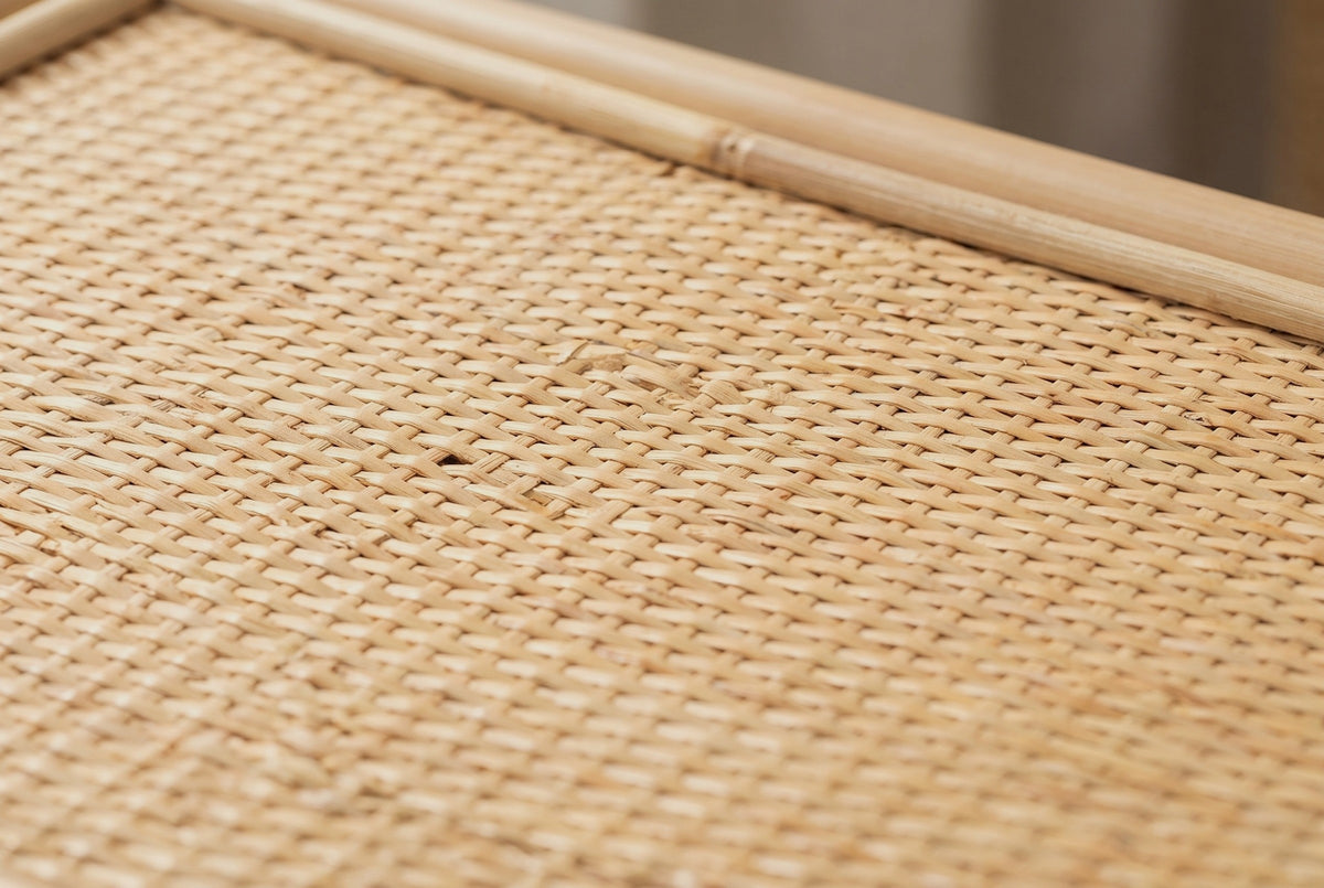 Close-up of the tightly woven natural rattan on the Sinnai nightstand top, with a round rattan pole along the edge