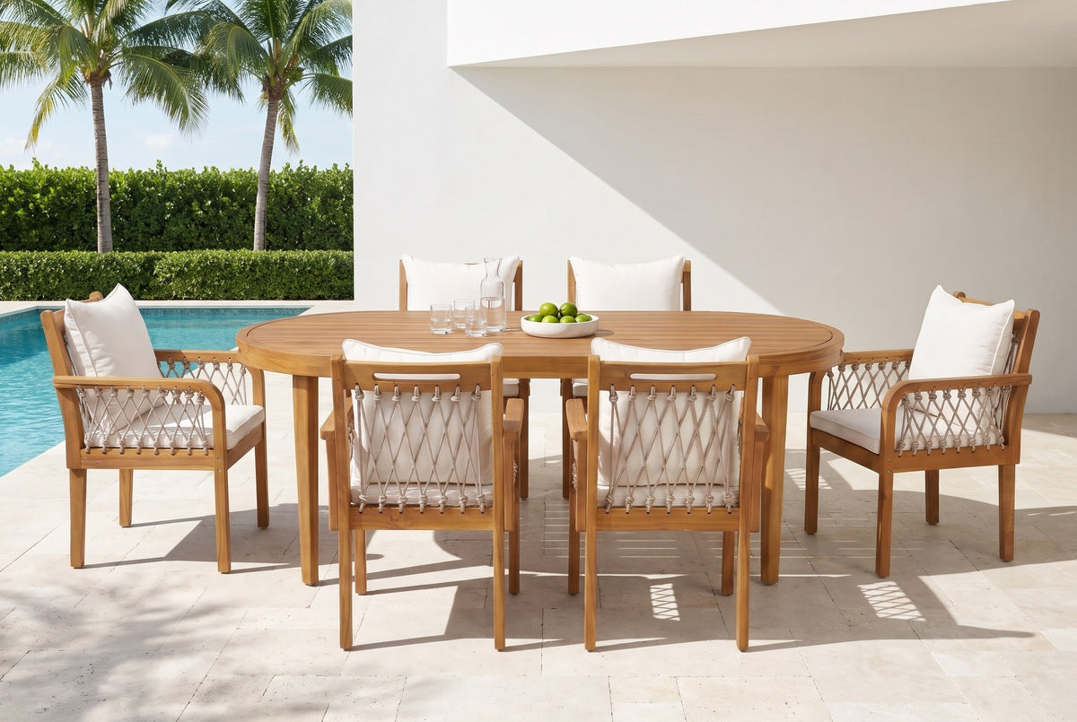Siracusa acacia oval dining set with six rope armchairs on a travertine pool terrace at a white stucco house in Naples, Florida, palms and a hedge behind (tableware not included)