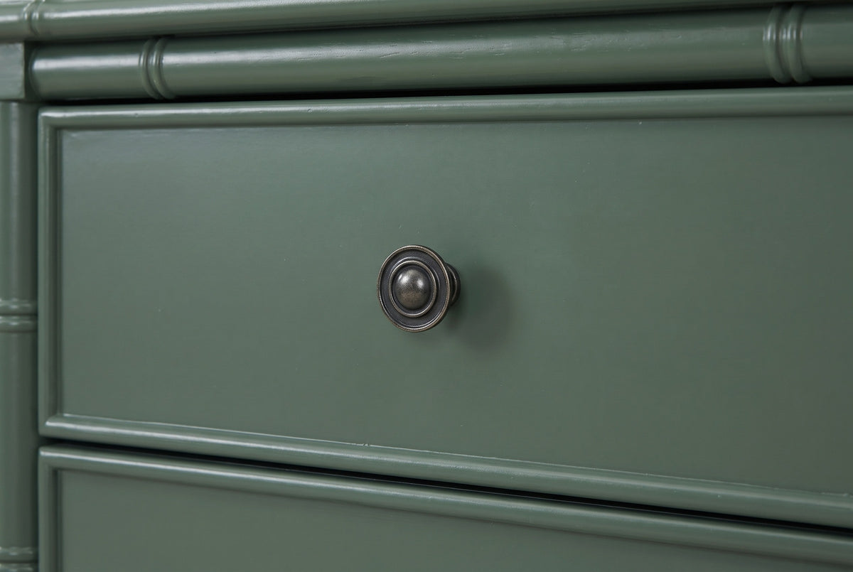 The upper drawer of the Sorgono nightstand: a round antique brass knob on a framed vintage green drawer front below a bamboo rail