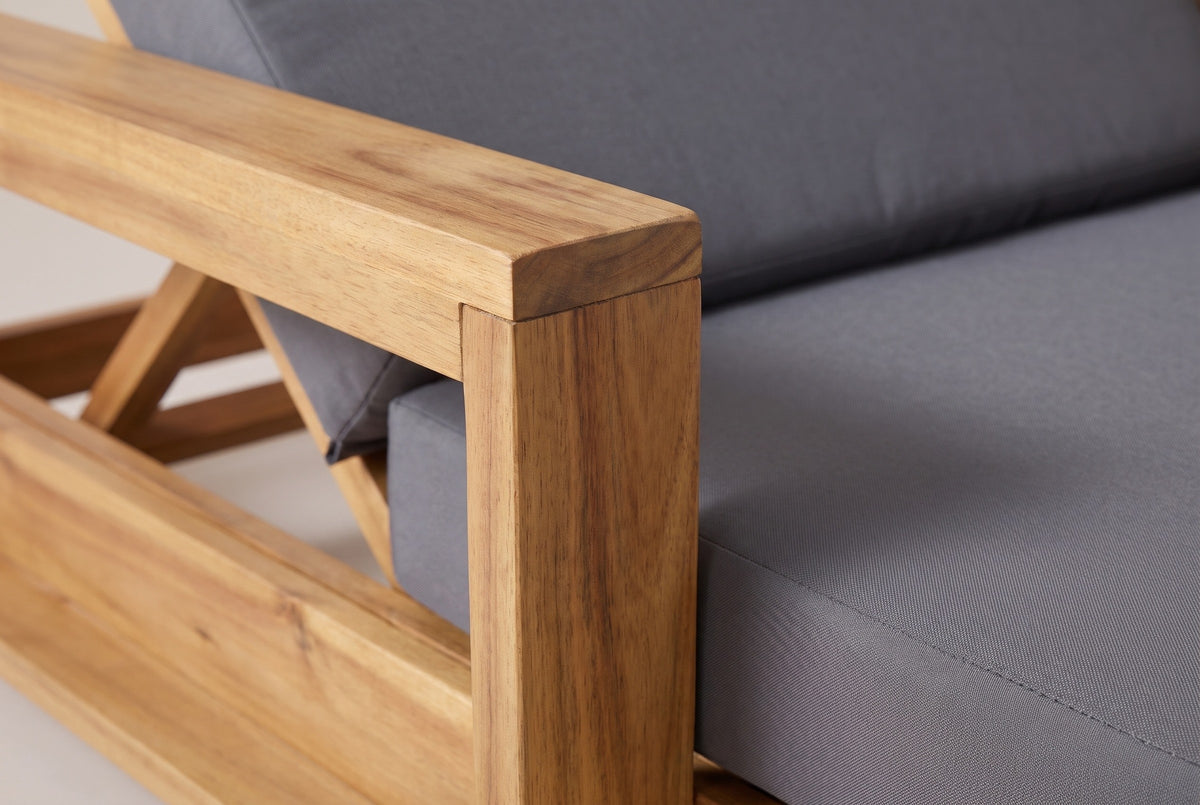 Close-up of the solid acacia on the Sortino chaise: the square post and top rail of a box arm in a light natural finish