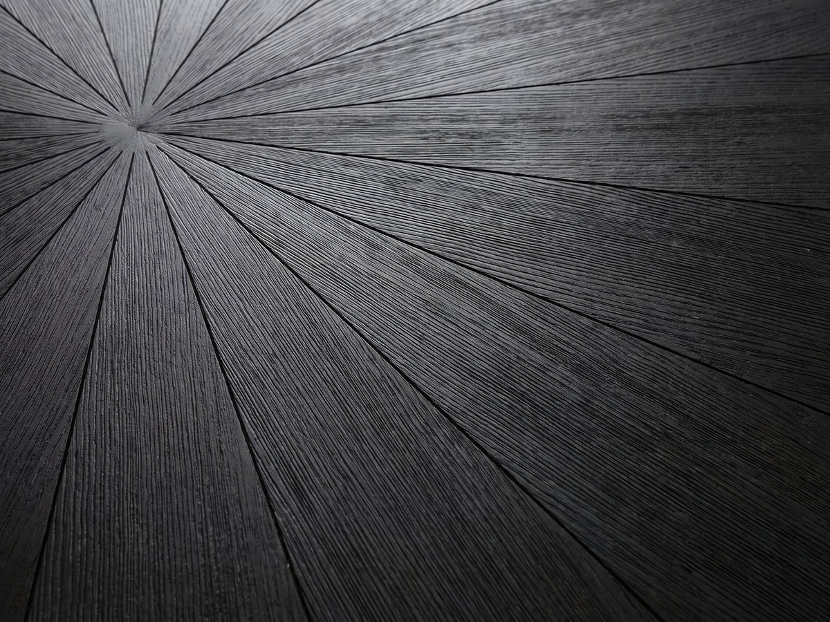 Close-up of the Soveria 63-Inch Round Black Acacia Sunburst Dining Table: the black wire-brushed acacia sunburst top