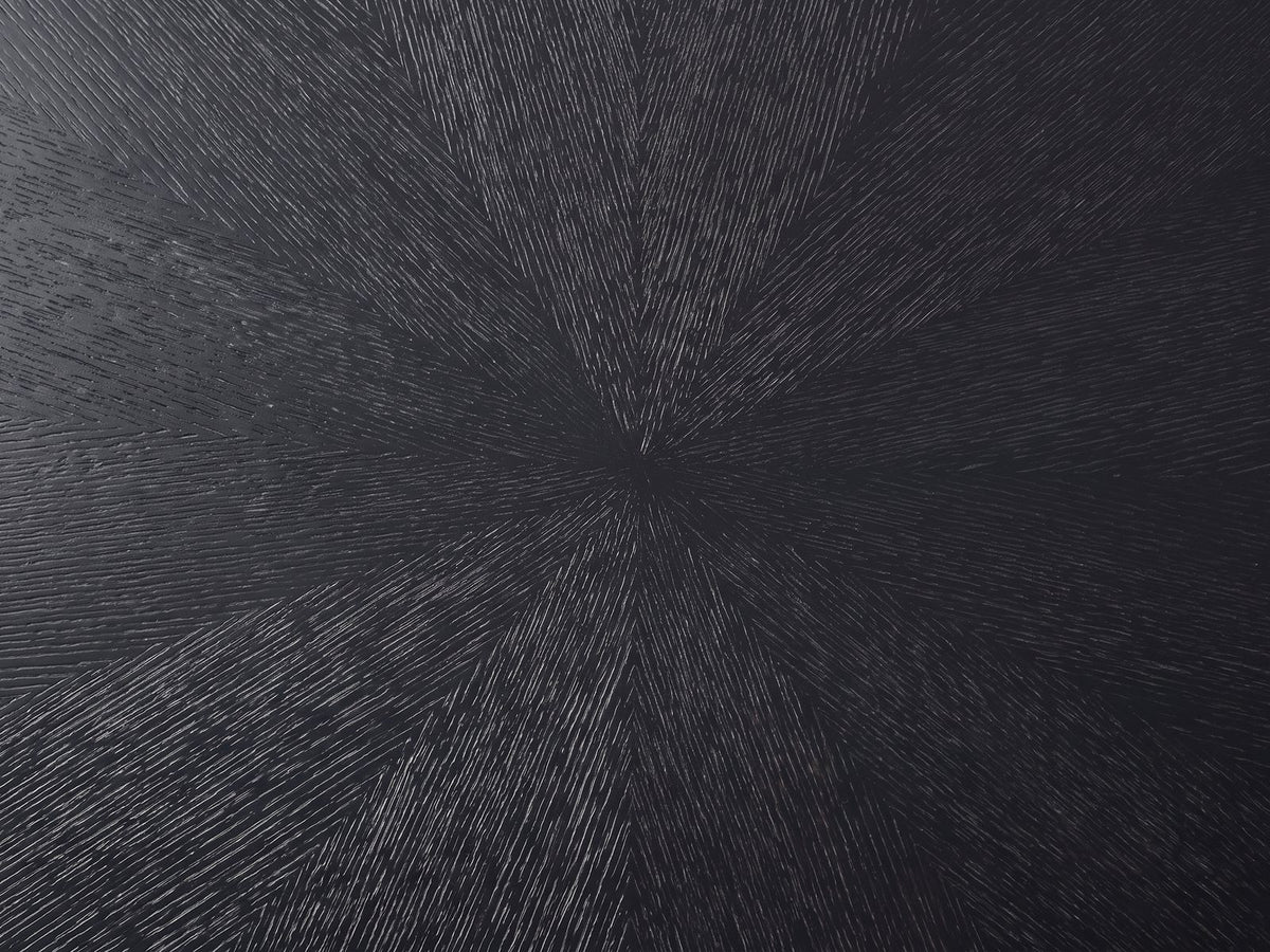 Close-up of the Spilimbergo Black Fiberglass Twisted Petal Coffee Table: the radial brushed sunburst texture of the black top