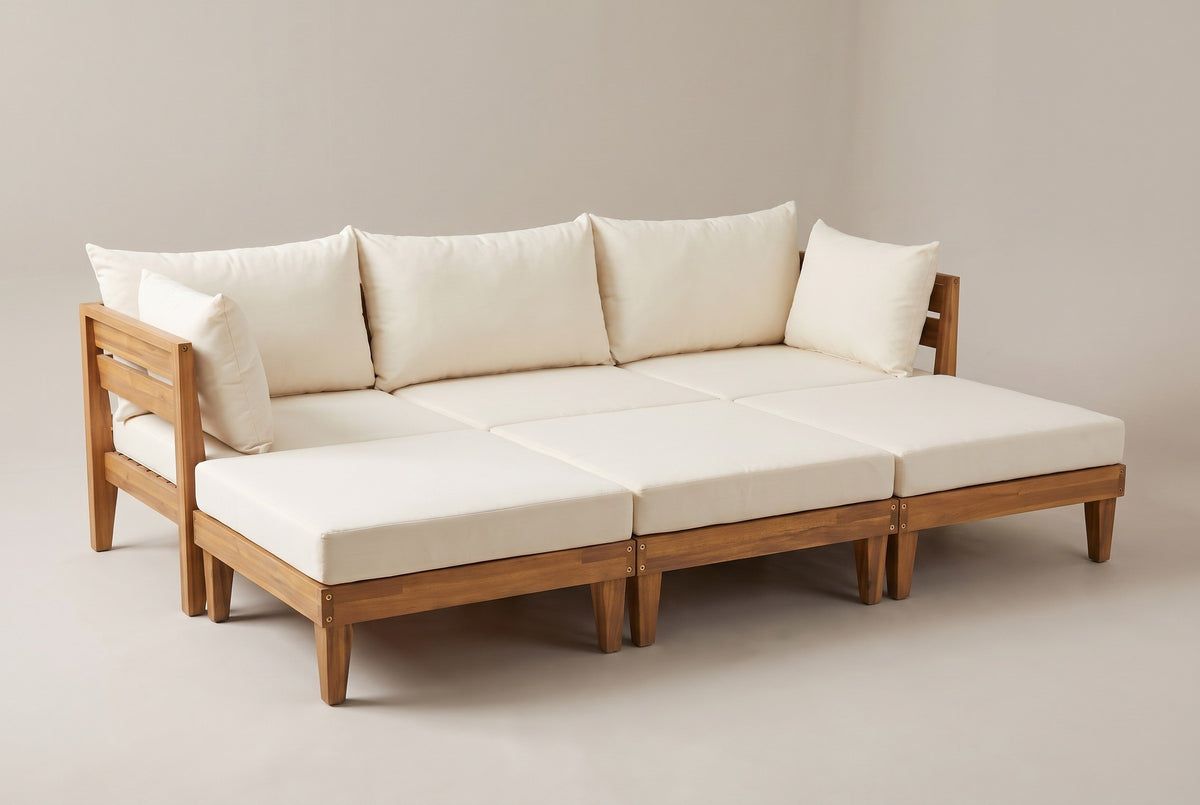 The Stromboli acacia daybed set with ivory cushions and pillows, three-quarter view on a light studio backdrop