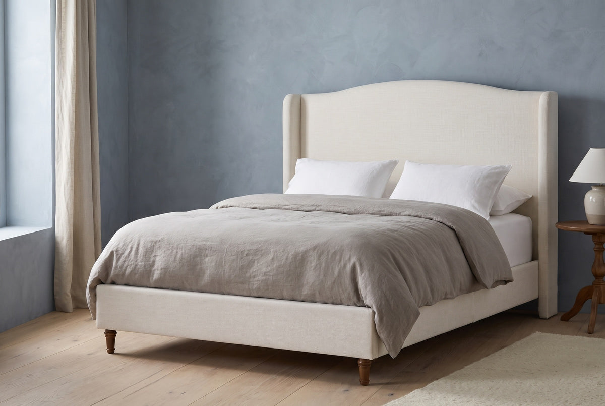Sulmona bed against a dusty slate-blue plaster wall in a Hudson Valley farmhouse bedroom with a white-oak floor and a linen curtain