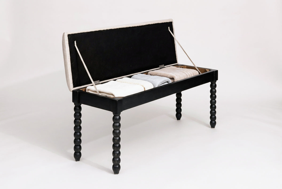 The Sutri bench with the seat lifted on two fabric straps: a black-lined lid above an open compartment holding three folded blankets