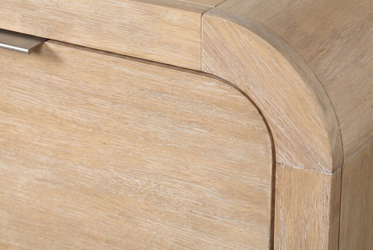 Close-up of the wire-brushed mango veneer on the Tempio nightstand where the top curves down into the side panel