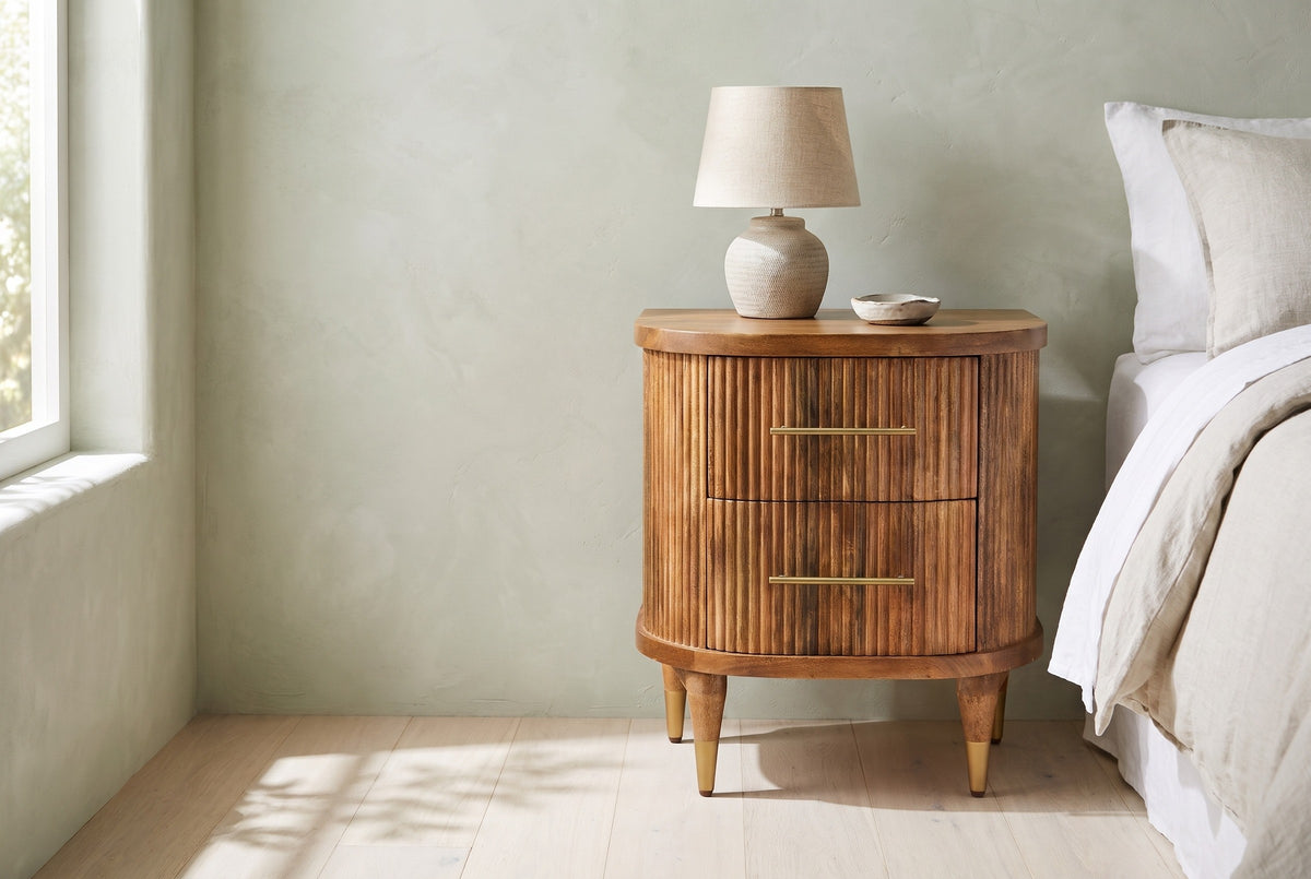 Thiesi reeded mango nightstand with a ceramic lamp beside a bed in a Napa Valley bedroom with a pale sage limewash wall