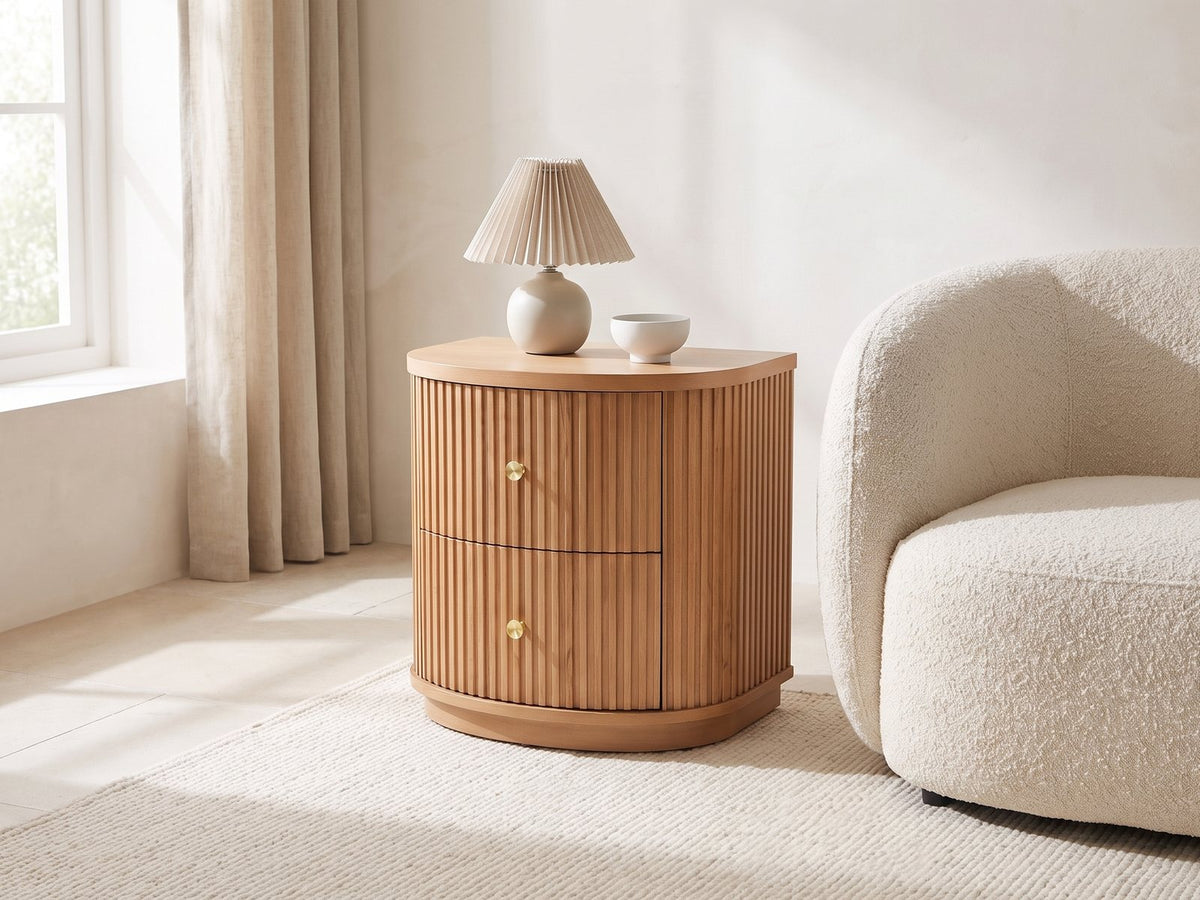 Tolfa Fluted Beech Half-Moon Side Table with a lamp and a ceramic bowl beside a cream boucle armchair in a bright plaster room