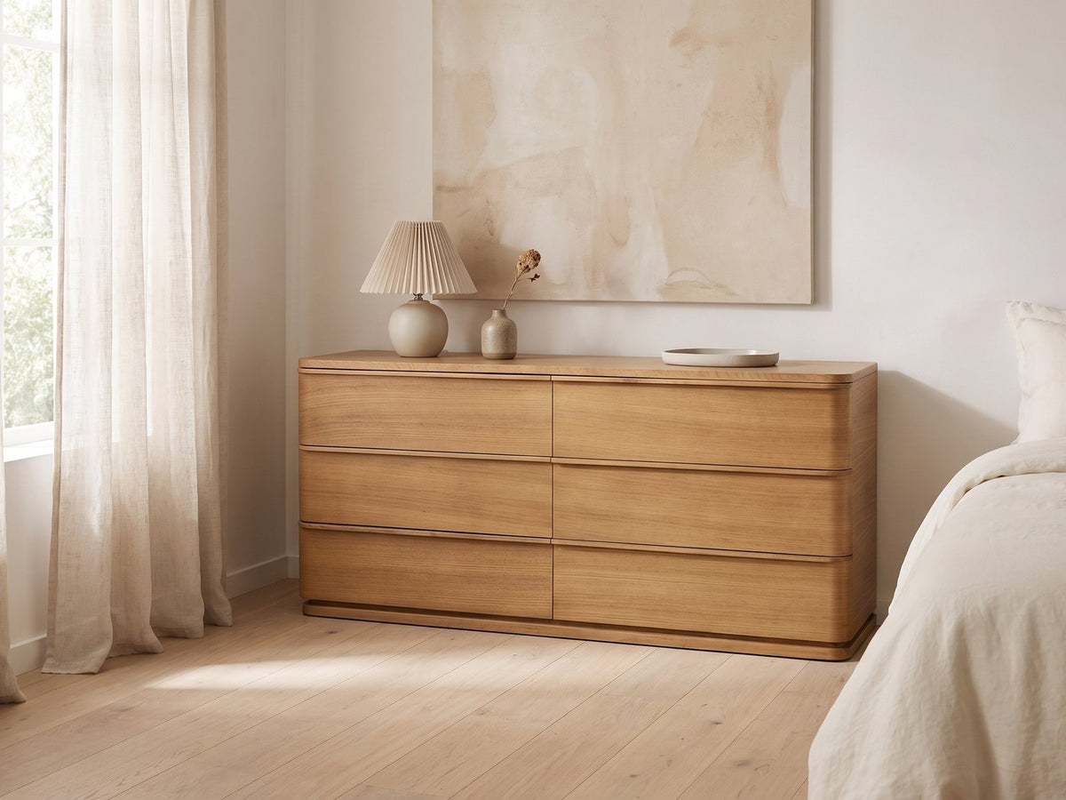 Tolmezzo 72-Inch Natural Oak 6-Drawer Dresser against a plaster wall under an abstract canvas in a bright bedroom