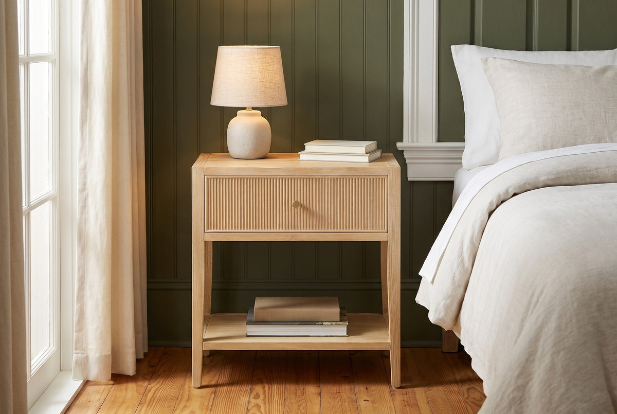 Tonara natural reeded nightstand against deep olive green wall panelling in a Savannah bedroom with heart-pine floors