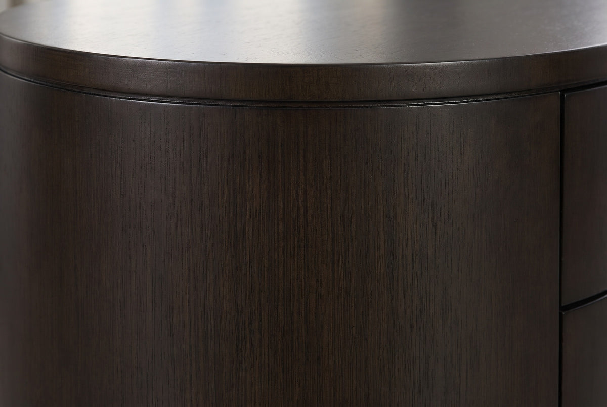 Close-up of the deep espresso eucalyptus veneer on the Tortoli nightstand: a fine straight grain under the thin edge of the oval top