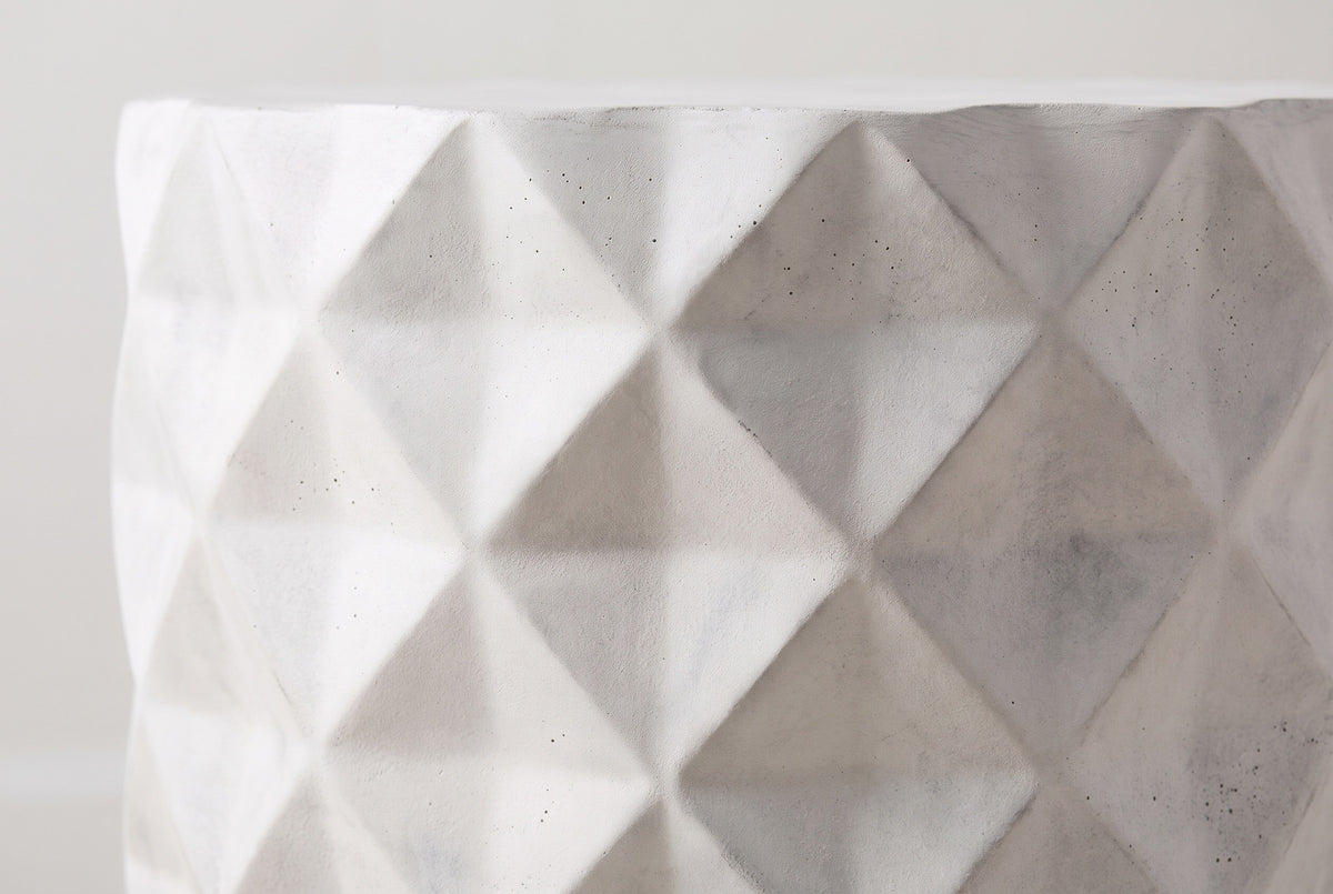Close-up of the antique white lightweight concrete on the Tortorici side table: shallow diamond facets with a faint grey wash and fine pores