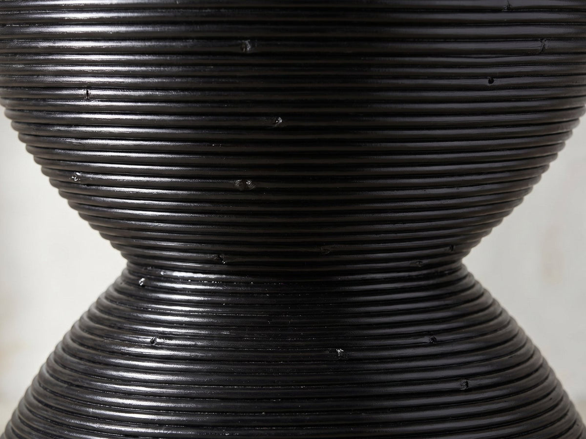 Close-up of the Tricase Black Rattan Hourglass Side Table: the coiled rattan poles at the hourglass waist