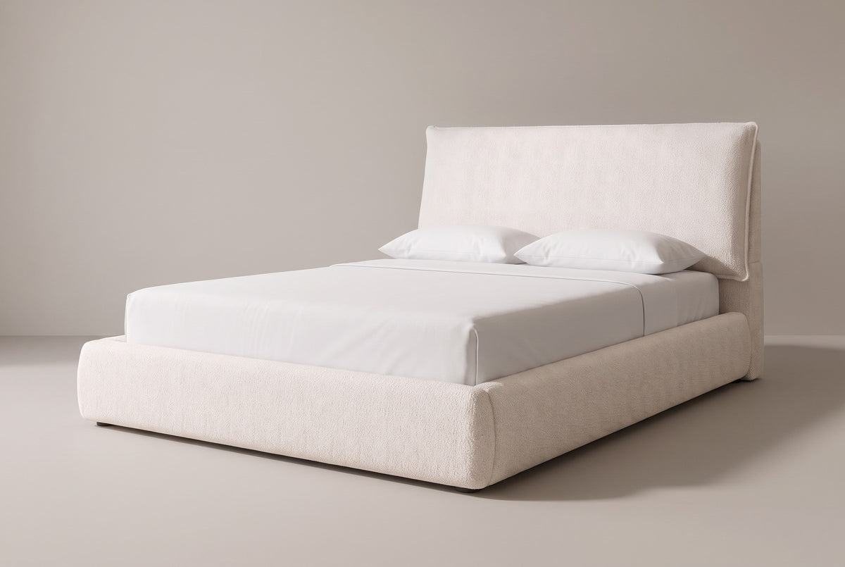 The Trivento pillow headboard bed in cream white chenille with a white mattress and pillows (not included), three-quarter view on a light studio backdrop