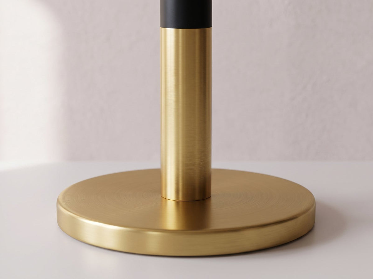 Close-up of the Ugento White Marble Pedestal Side Table: the black and gold column on its gold base disc
