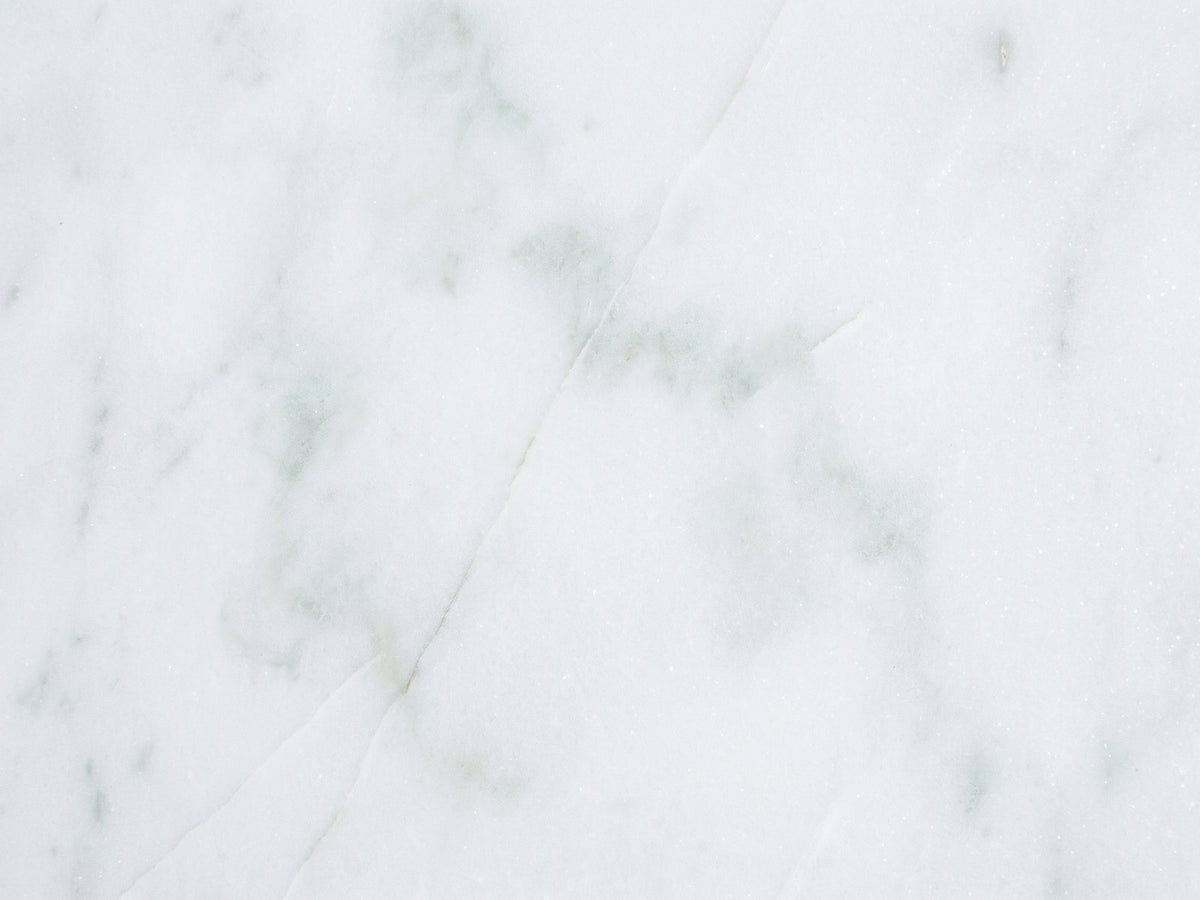Close-up of the Ugento White Marble Pedestal Side Table: the genuine white marble of the top