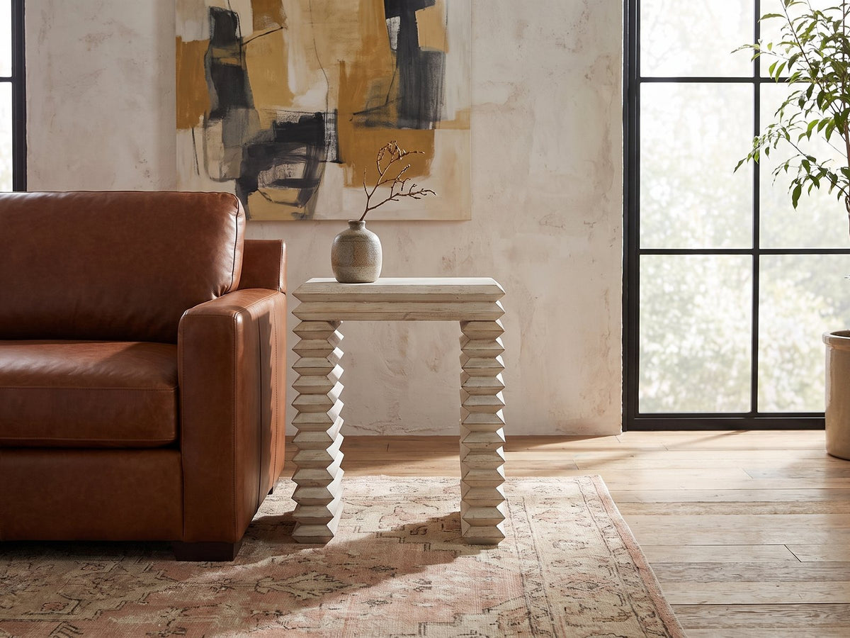 Varallo Reclaimed Pine Side Table beside a leather sofa in an industrial loft