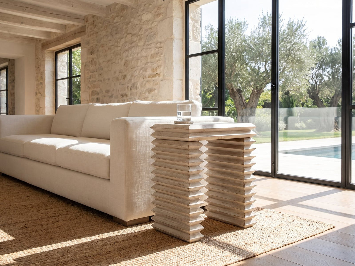 Varallo Reclaimed Pine Side Table beside a linen sofa in a poolside villa