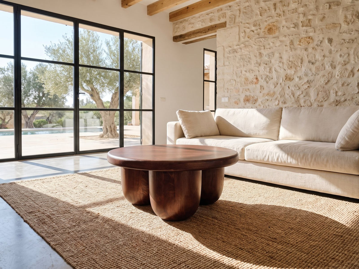 Bolgheri Sculpted Mango Coffee Table on a jute rug in front of a linen sofa in a poolside villa