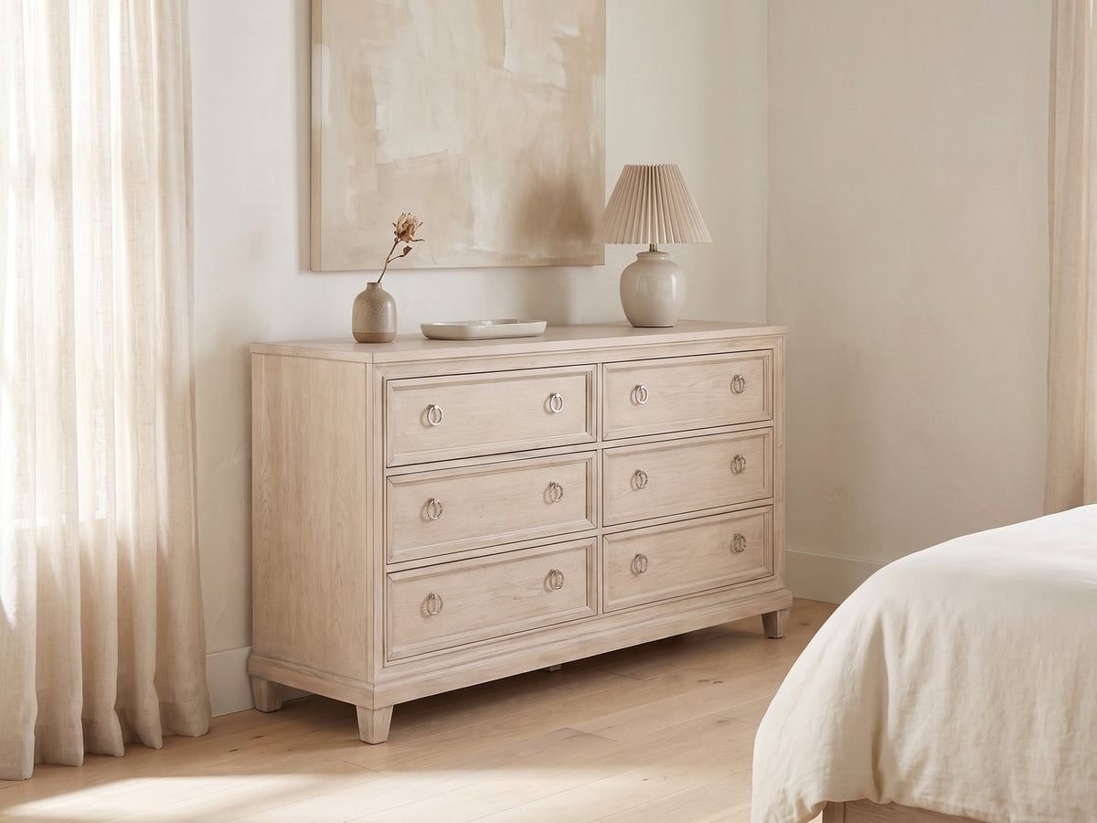 Vittorio 62-Inch Washed Oak 6-Drawer Dresser against a plaster wall under an abstract canvas in a bright bedroom