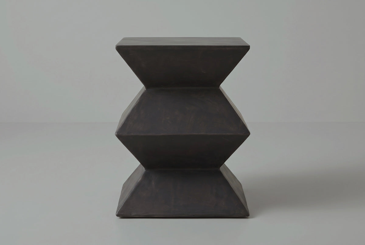 The Zafferana side table seen straight from one side: a zigzag outline with two narrow waists between a square top and base