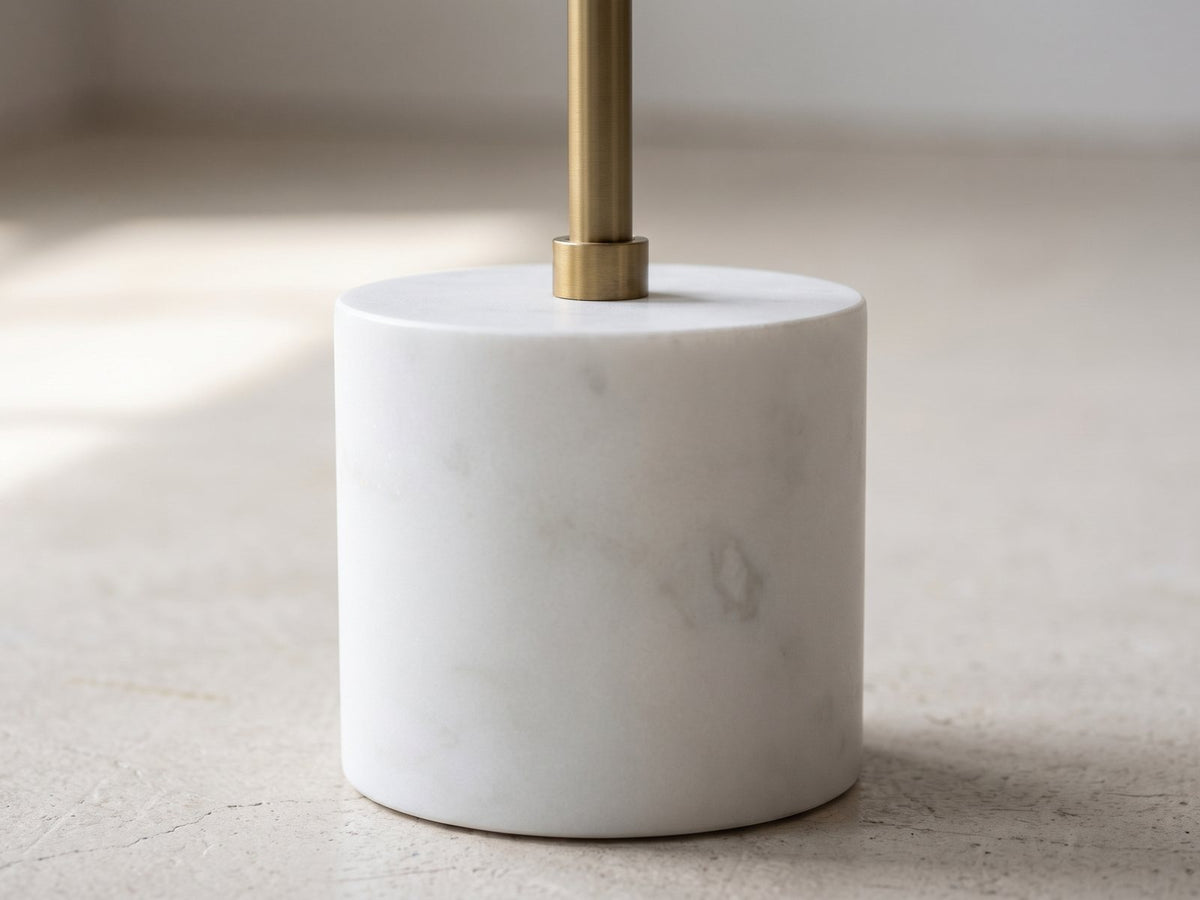 Close-up of the Zollino Mango and Marble Pedestal Side Table: the brass rod and collar rising from the white marble base