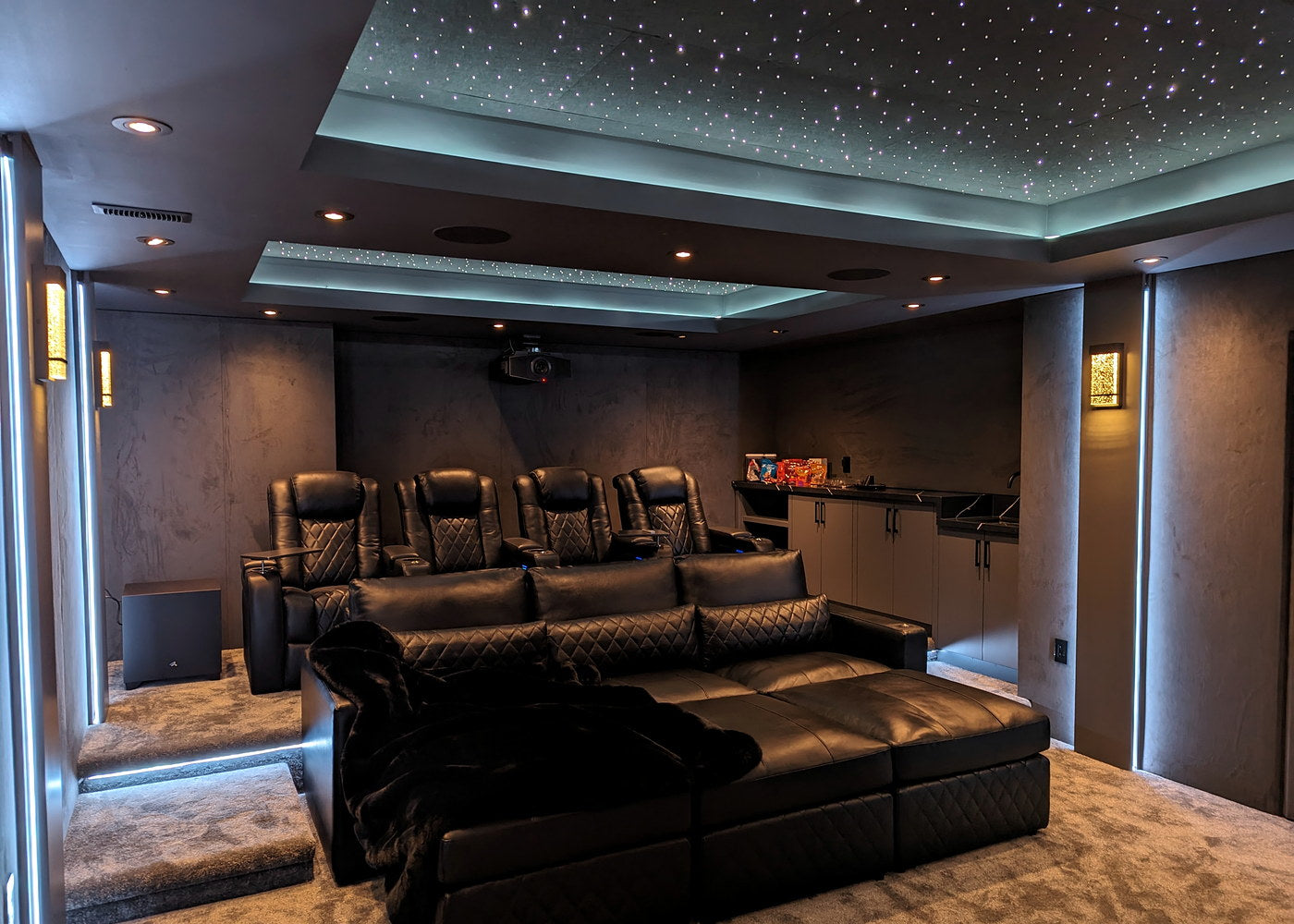 Home theater with an illuminated Starlight Ceiling above the seating