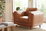 A Valencia Artisan Leather Accent Chair in rich Cognac color, crafted with premium leather that promises to age gracefully. Its sturdy wooden legs provide stability, while the generously - padded seat and armrests offer ultimate comfort. Placed in a bright room with natural light streaming in, surrounded by plants and books on a side table. This chair blends style and functionality, adding a touch of elegance to any space.

