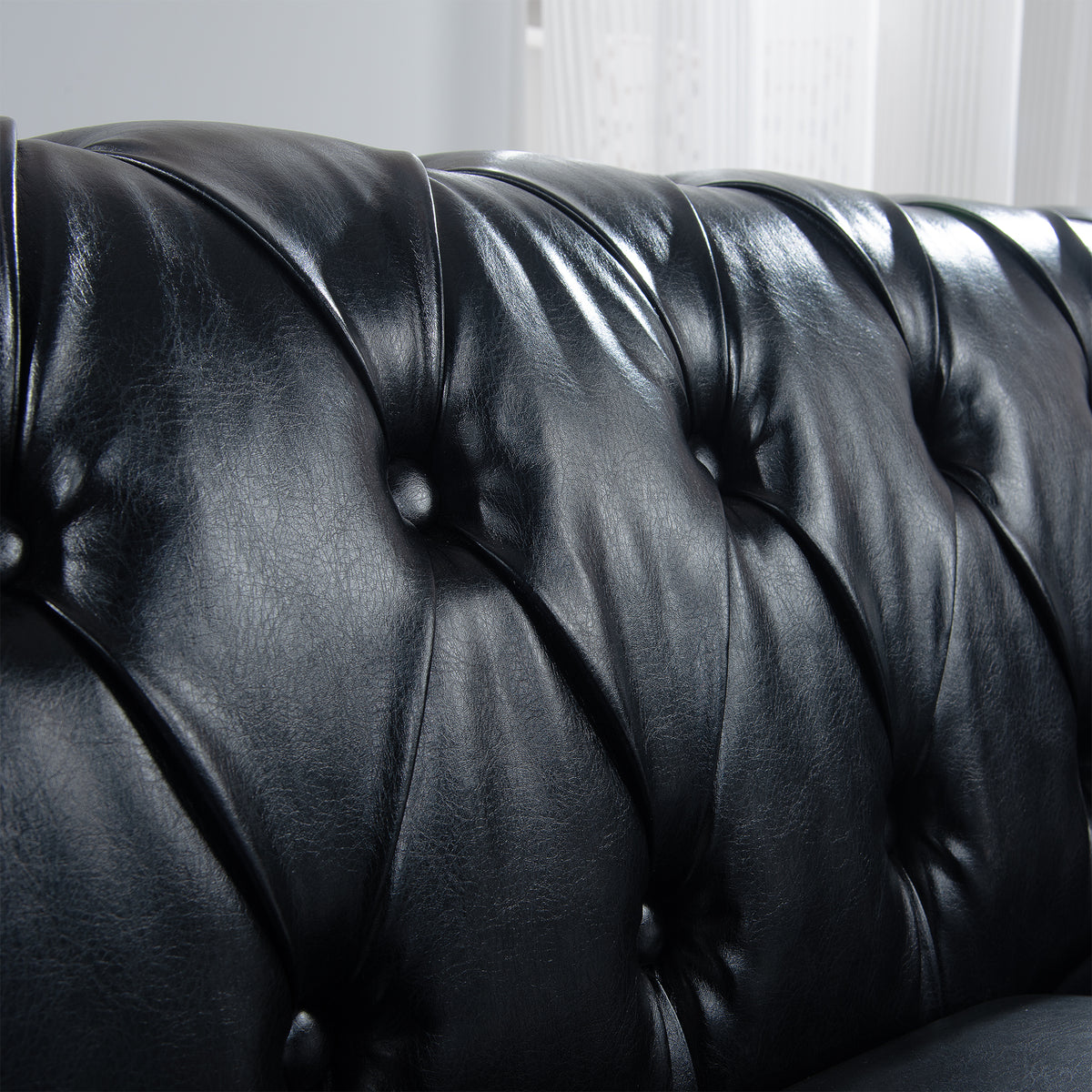 Deep button tufting across the black faux-leather backrest
