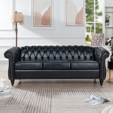 Black faux-leather Chesterfield sofa styled in a living room, front view