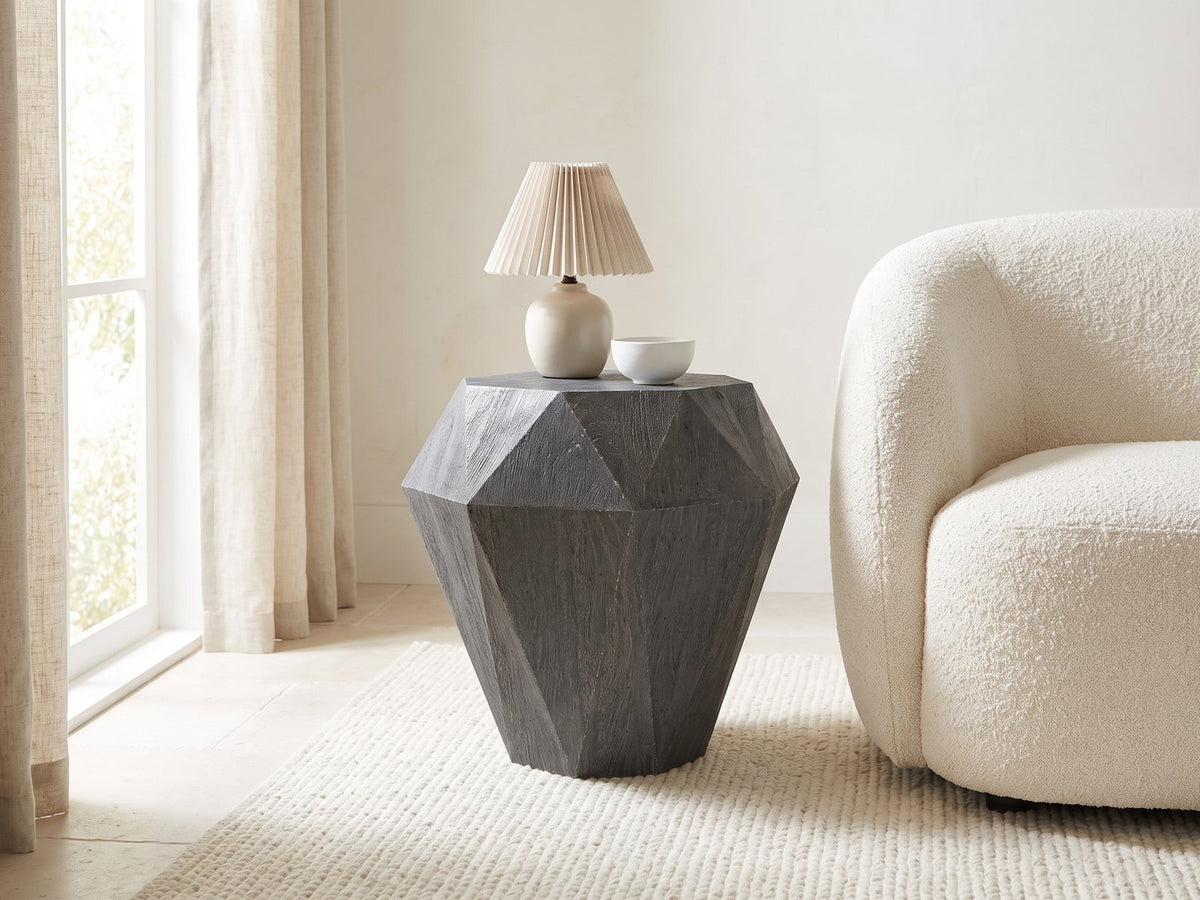 Accadia Grey Mango Faceted Octagon Side Table with a lamp and a ceramic bowl beside a cream boucle armchair in a bright plaster room
