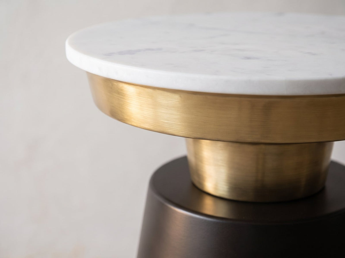 Close-up of the Acerenza White Marble Pedestal Side Table: the marble top on the gold-tone tray, stem and black cone