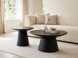 Acqui 29-Inch Round Ebony Oak Veneer Pedestal Coffee and End Table Set styled with books, a vase and a stone bowl in front of a cream sofa in a bright plaster room