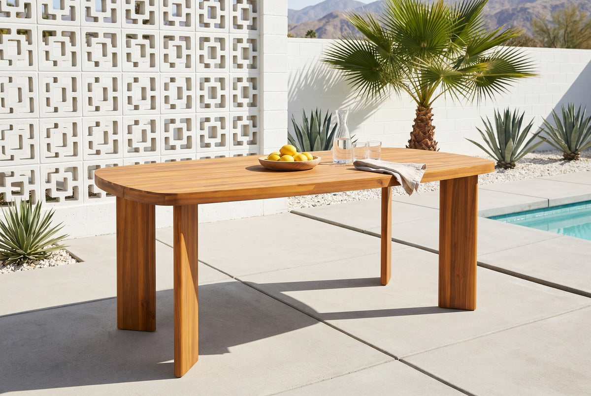 Adrano acacia dining table on pale concrete pavers by a pool in Palm Springs, a white breeze-block screen wall, a fan palm, agaves and the mountains behind (chairs not included)