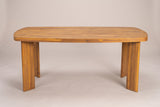 The Adrano dining table seen from the long side: the planked top with rounded ends on four solid acacia slab legs