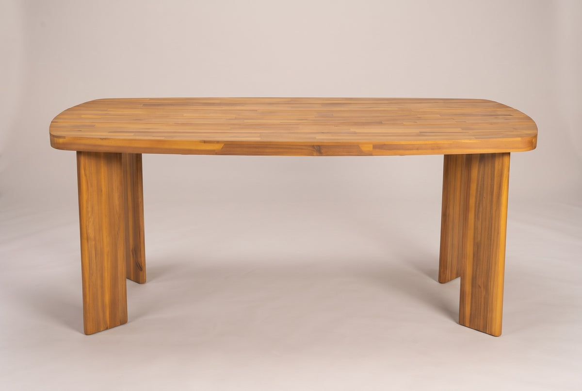 The Adrano dining table seen from the long side: the planked top with rounded ends on four solid acacia slab legs