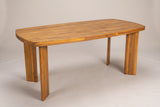 The Adrano acacia outdoor dining table in a teak finish, three-quarter view on a light studio backdrop
