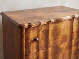 Close-up of the Adria 34-Inch Chestnut Solid Mango 3-Drawer Chest: the scalloped moulded top edge above the serpentine drawer fronts and their ringed knobs