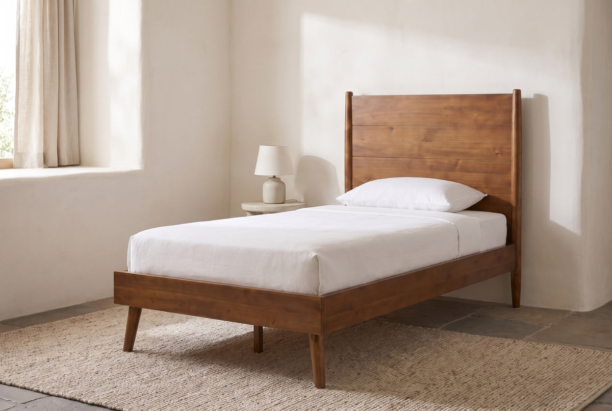 Agnone bed against a warm white adobe wall in a Santa Fe bedroom with a deep window, a flagstone floor and a woven rug