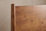 Close-up of the Agnone headboard: a slim round acacia post with a rounded top beside the horizontal boards