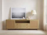 Alassio 80-Inch Sand Wash Ash and Rattan Media Console styled with a leaning print, a lamp and ceramics in a bright plaster room