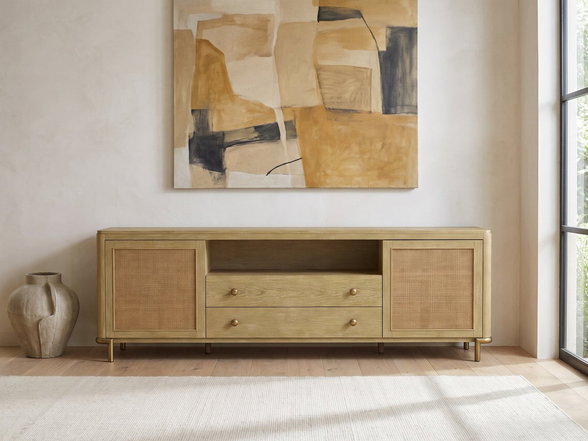 Alassio 80-Inch Sand Wash Ash and Rattan Media Console under a large abstract painting in a bright living room
