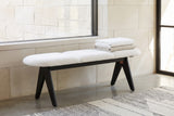 Alatri white fabric bench under a long window ledge on a pale limestone wall in a Dallas living room, with folded blankets on the seat and a wool rug on a concrete floor (blankets and rug not included)