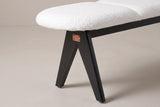 One end of the Alatri bench: the rounded end of the white fabric seat, a rail beneath it, a small copper-tone plate with four screws at the joint, and two flat black legs spreading apart below