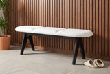 Alatri white fabric bench against a walnut slat wall in a Minneapolis hallway with a stone tile floor, a potted plant and a pair of slippers on the floor (plant and slippers not included)