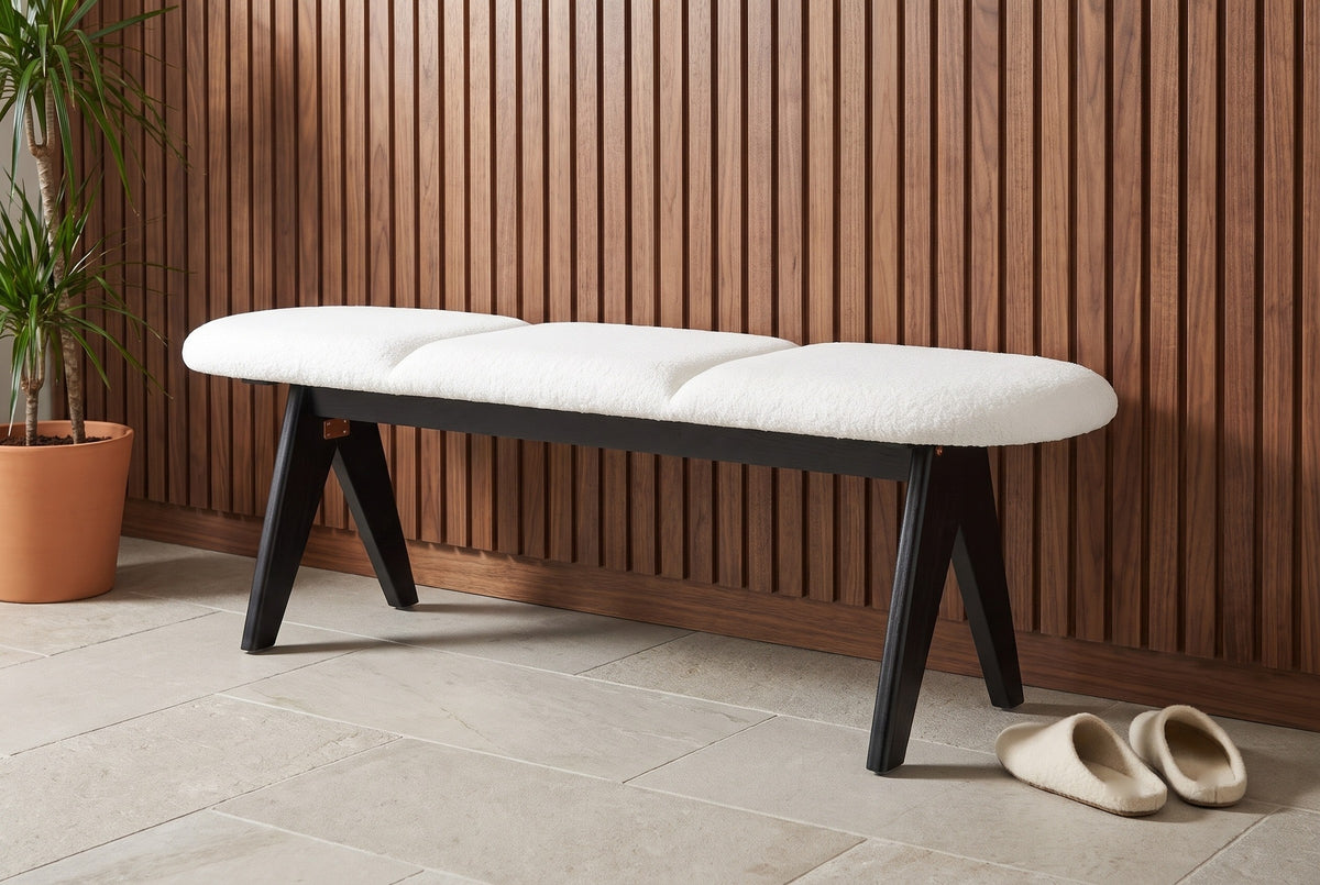 Alatri white fabric bench against a walnut slat wall in a Minneapolis hallway with a stone tile floor, a potted plant and a pair of slippers on the floor (plant and slippers not included)