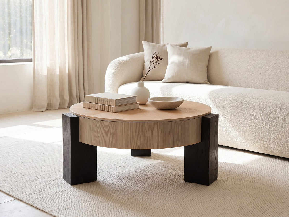 Alba 31.5-Inch Round Parquet Wood Veneer Storage Coffee Table styled with books, a vase and a stone bowl in front of a cream sofa in a bright plaster room