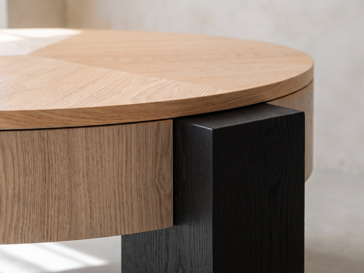 Close-up of the Alba 31.5-Inch Round Parquet Wood Veneer Storage Coffee Table: a black block leg clasping the veneered drum under the lid